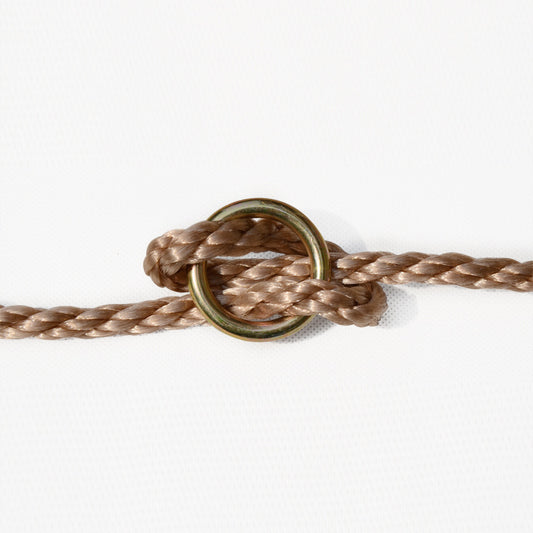 Kid climbing on a wooden rope ladder suspended in the air