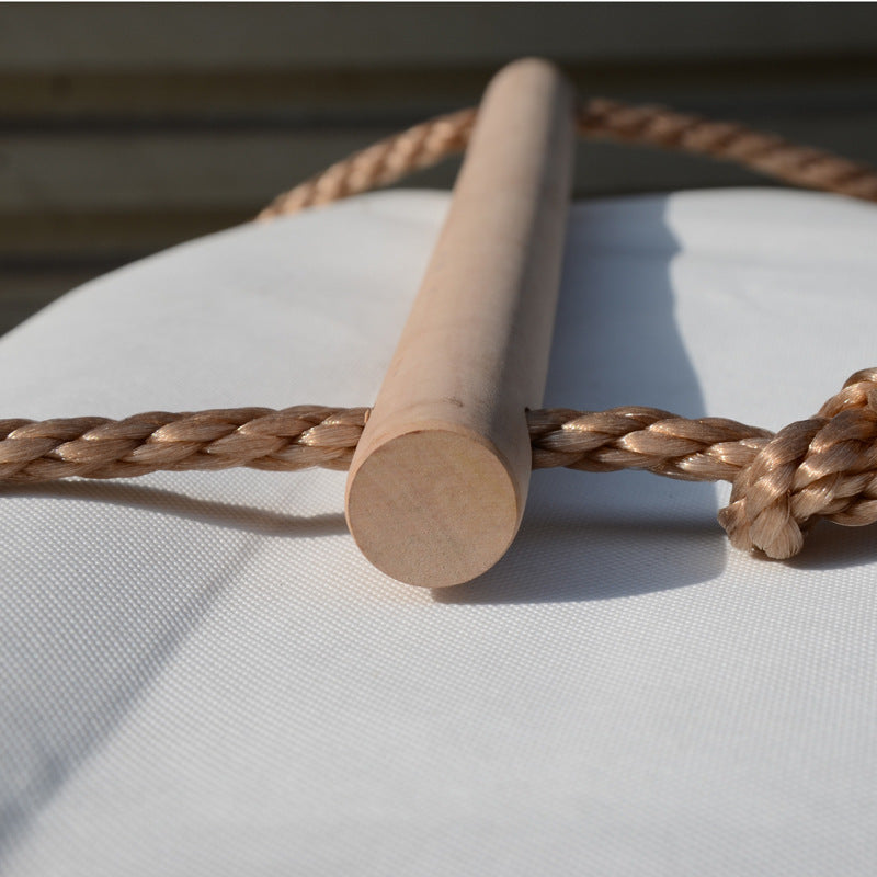 Kid climbing on a wooden rope ladder suspended in the air