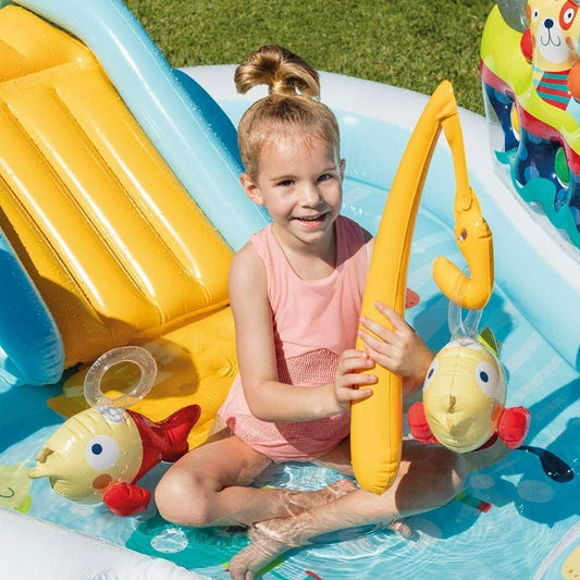 Children playing in a large inflatable slide pool with palm tree and lighthouse