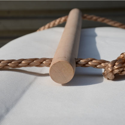 Kid climbing on a wooden rope ladder suspended in the air