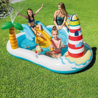 Children playing in a large inflatable slide pool with palm tree and lighthouse