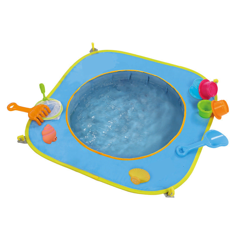 Child playing on a blue water pocket mat with beach toys